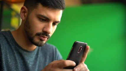 Man using phone against green screen background for mockup or graphic design