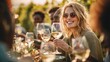 © Johannes - Happy adult friends having fun drinking white wine and eating together with vineyard in background - Multiracial people doing dinne at summer time in countryside resort - Main focus on blond girl fac