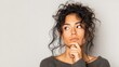 © Johannes - Isolated portrait of stylish young mixed race woman with dark shaggy hair touching her chin and looking sideways with doubtful and sceptical expression, suspecting her boyfriend of lying to her, no l