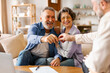 © Home-stock - Realtor giving senior couple key to new house at meeting, owners making purchase deal, family bought or rented apartment