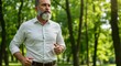© Bocx - Mature man jogging in a park, enjoying nature and exercise, maintaining a healthy lifestyle