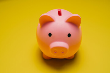 Poster - Saving money concept. Cute Pink Piggy Bank on Bright Yellow Background Representing Savings and Financial Planning for Children and Adults