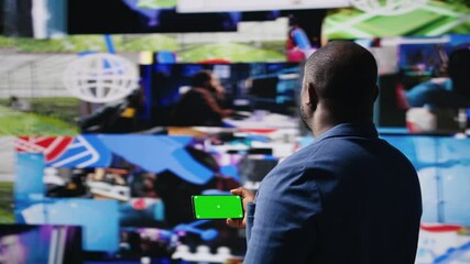 Poster - African american user holding a phone with isolated mockup display, digital system of networks and apps on dashboard. Highlighting the integration of AI and fintech. Multitasking. Camera A.
