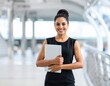 © Aditya - A woman confidently holds her laptop, ready to tackle the day ahead.