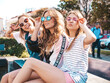 © halayalex - Portrait of three young beautiful smiling hipster female in trendy summer clothes. Sexy carefree women posing on the street background.Positive models having fun in sunglasses.Hugging