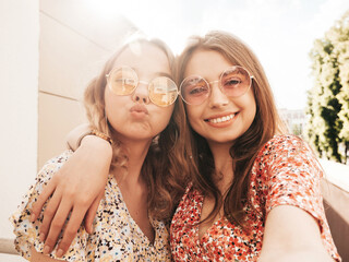 two young beautiful smiling hipster female in trendy summer sundress.sexy carefree women posing on t