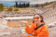 © EdNurg - Tourist admiring the ancient Asklepion Theatre in Pergamon, Turkey, a world heritage site, showing its well preserved stage and seating area