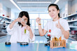 © Creativa Images - Mother Encouraging Young Girl Conducting Science Experiment in Laboratory