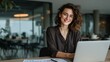 © Rifqi - Confident young professional woman smiling happily using generic laptop computer mockup at modern office desk representing successful business career innovation achievement and