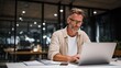 © Rifqi - Mature businessman with glasses intensely focused working on modern laptop computer mockup during late hours in contemporary office environment symbolizing dedication technology