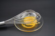 © Yurii Levko - Whisking vibrant egg yolk in a clear bowl on a dark surface during a culinary creation