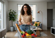 © budi - Happy woman with groceries in shopping cart inside her modern apartment.