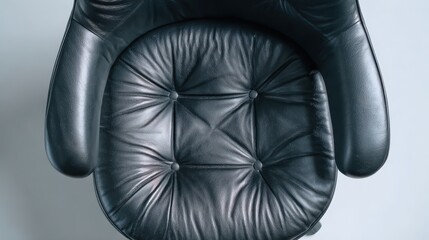 Poster - Capturing a top view of a comfortable black leather office chair on a plain background, highlighting its elegant design and inviting cushioning for a modern workspace