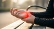 © Clifford - person holding painful wrist with red highlighted discomfort