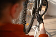 © Andrii Lysenko - Close-up of woman adjusting bike rear derailleur with equipment