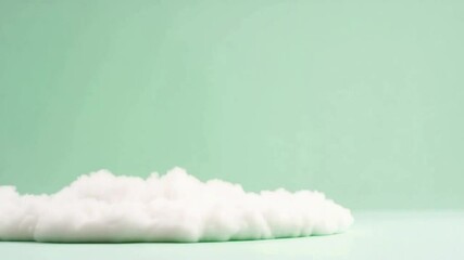 Poster - Cotton Cloud on pastel green background: A fluffy cotton cloud rests gracefully against a serene pastel green backdrop, evoking a sense of lightness and serenity in a minimalist scene. 