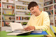 © New Africa - Student with books studying at table in library. Space for text