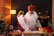 © New Africa - Saint Nicholas with gift list at desk in room decorated for Christmas