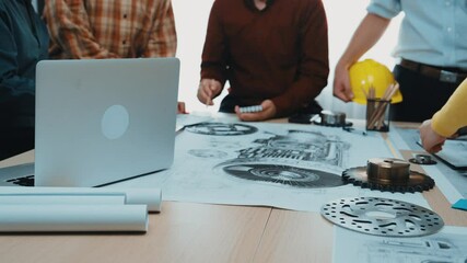 Poster - A group of engineers collaborates in a modern office, discussing technical drawings and digital devices on a workspace table while exploring innovative mechanical designs. SACTR