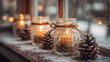 © Olshanetskaia - A cozy winter scene with glass jars holding candles, surrounded by pine cones and snow on a windowsill. Soft light glows through the glass, creating a warm atmosphere.