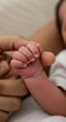 © Mauricio - A tiny newborn baby hand grips a parents finger tightly