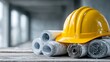 © Anan - Business Project Management Yellow Construction Helmet on Architectural Blueprints in Workspace