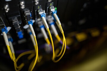 Poster - Yellow fiber cables are plugging into switch ports with boots and green LEDs in flat design