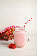 Wall Mural - Mason jar of tasty strawberry smoothie on table
