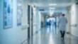 © Worldwide - Blurry hospital corridor with medical staff walking.