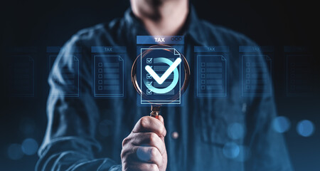 Poster - Businessman holding magnifying glass over virtual tax checkmark form, illustrating tax compliance and audit concept on dark blue background..