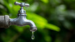 © Jan - Outdoor Faucet Dripping Water, Symbolizing Water Conservation, Scarcity, or Waste, with a Fresh Green Natural Background Highlighting Environmental Concerns
