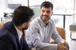 © fizkes - Friendly conversation. Happy millennial professional sit on couch enjoy talk with workmate business partner share successful project results financial growth career achievement perfect sales strategy