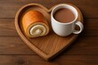 ©  AugmentArt - Cream-filled sweet roll served with hot chocolate on a rustic wooden heart-shaped tray