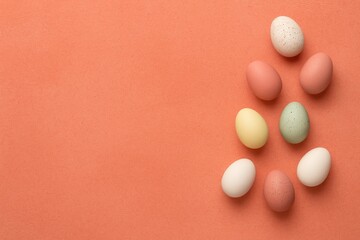 Poster - Springtime Easter scene featuring colorful eggs on a coral backdrop with ample space for text. Simple and elegant holiday theme.