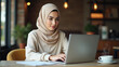 © ahmet - Young Muslim Woman in Hijab Working on Laptop at Cozy Modern Café – Realistic Candid Style