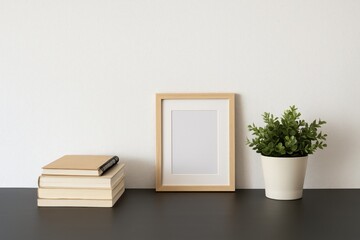Poster - A tidy home office setup featuring a dark desk with a book, notebook, photo frame, and potted plant against a white cement wall backdrop