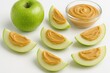 © The 2R Artificiality - Healthy snack idea: apple slices with peanut butter on a white background