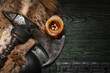© Dmitriy - Medieval Viking axe and warrior wooden green black shied on old warrior table close up background.