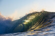 © Nautilus Creative - A beautifully vibrant backlit emerald coloured glassy surfing wave breaking over a shallow reef. Captured from the ocean's surface on sunrise.