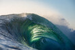 © Nautilus Creative - A beautifully vibrant backlit emerald coloured glassy surfing wave breaking over a shallow reef. Captured from the ocean's surface on sunrise.