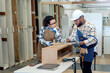 © BESTIMAGE - Two colleague young aged carpenter standing aim equipment tool for wood furniture at wood plank in workshop. coworker carpenter working craft with wood diy tool in workbench shop carpentry