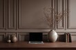 © Eleven room - A laptop sits on a wooden desk, in front of a taupe-colored wall with decorative panelling.  Dried plant branches in a vase are also on the desk
