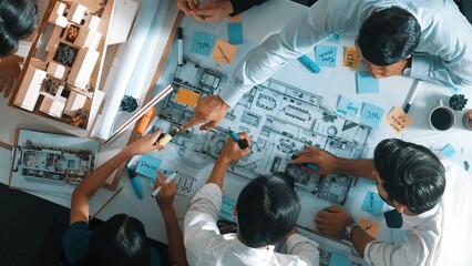 Poster - Top aerial view of project manager or civil engineer writing at blueprint and planning building design. Aerial view of architect working together at meeting table with document placed. Alimentation.