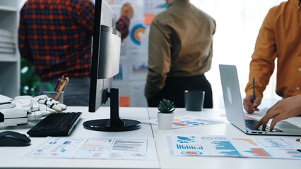 Poster - A modern office environment showcasing a business team engaged in data analysis, using technology and documents to drive insights and enhance teamwork.Noogenesis