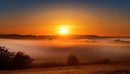 Wall Mural - sunrise with glowing orange light and mist over horizon glowing orange sun rising with mist