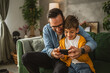 © Miljan Živković - Father and son play video games on a mobile phone and enjoy at home