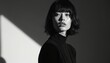 © Viktor - Black, white portrait of young woman in black turtleneck against minimalistic background. Face features subtle makeup, soft lighting. Image modern, elegant feel, suitable for fashion beauty content.