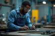 © Viktor - Black man in blue overalls, safety glasses works diligently in metal workshop. Uses tools on workbench, focusing on metal bars. Scene highlights precision, craftsmanship, industrial environment,