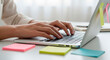 © DentinCrazy - Hands Typing on a Laptop Keyboard Surrounded by Sticky Notes
