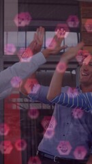 Poster - Animation of icons floating over happy diverse coworkers clapping hands in office